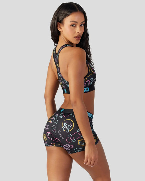 Black sports bra and shorts set with colorful neon line art graphics on dark background.