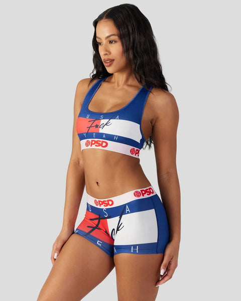 Woman wearing blue, red, and white sports bra and boyshort set with text graphics and PSD branding.