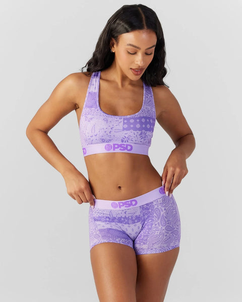 Woman wearing purple bandana-print sports bra and matching boy shorts with PSD branding.