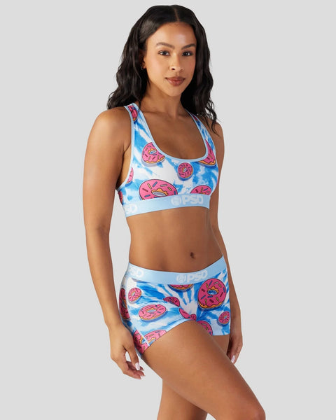 Woman wearing blue and pink donut-print sports bra and shorts set with elastic waistbands.