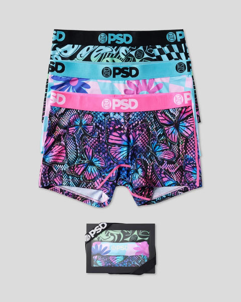 Three PSD boxer briefs in black geometric, turquoise solid, and pink butterfly patterns with branded waistbands, shown stacke