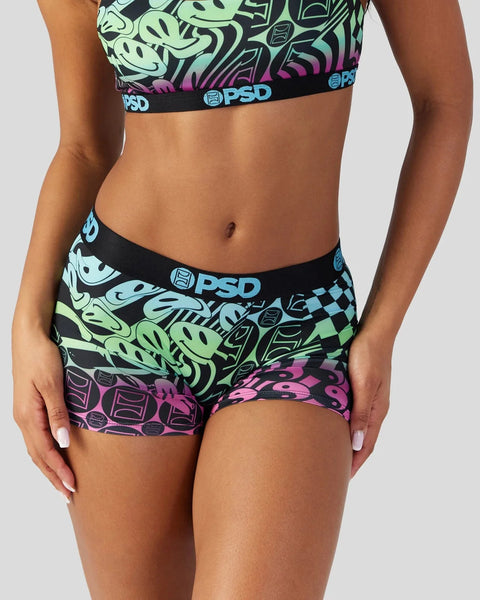 Woman wearing green, purple, and black patterned sports bra and underwear set with PSD branding.