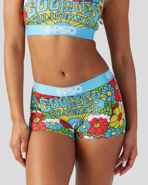 Person wearing multicolored floral print crop top and shorts with light blue PSD waistband.