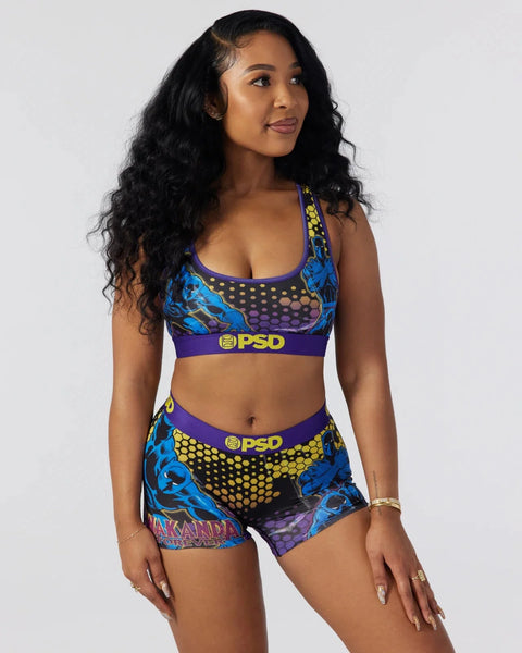 Woman wearing Black Panther-themed sports bra and shorts set with blue, purple, and yellow geometric print and PSD branding.
