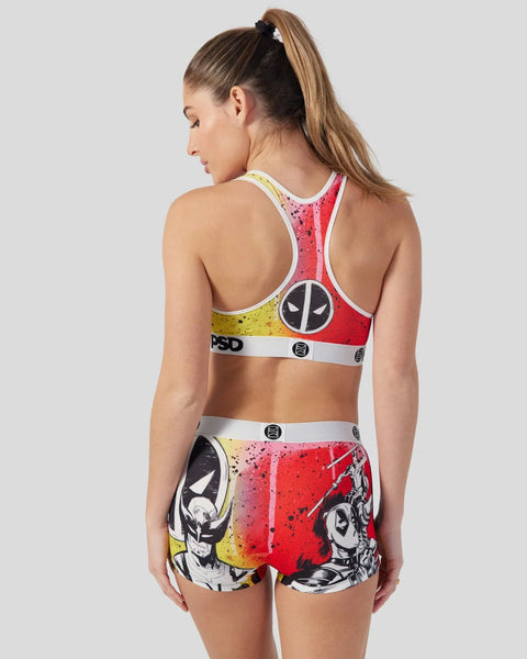 Woman wearing red, yellow, and black Deadpool and Wolverine sports bra and shorts set with character graphics and PSD waistba