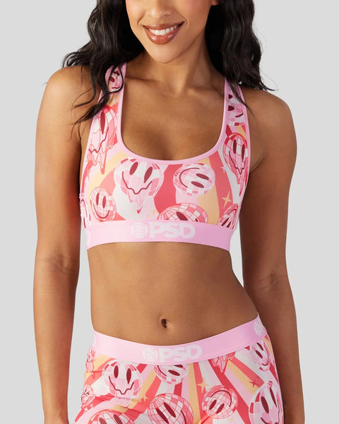 Pink sports bra with smiley face and geometric print pattern in red, yellow, and white tones.