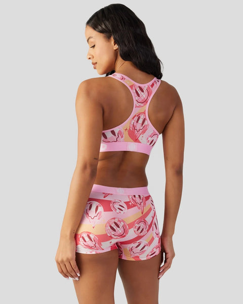Pink sports bra and shorts set with smiley face pattern in red and cream tones.