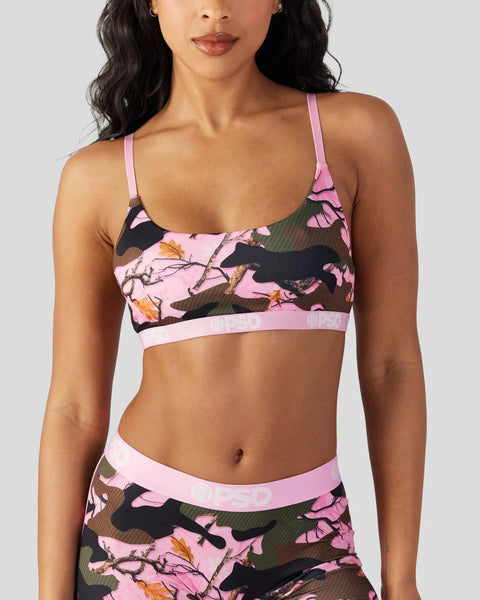 Pink and black camo sports bra with yellow floral details and adjustable straps.