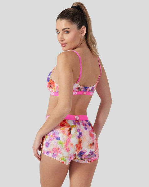 Woman wearing a two-piece swimsuit with colorful floral print and pink trim, shown from back at an angle.