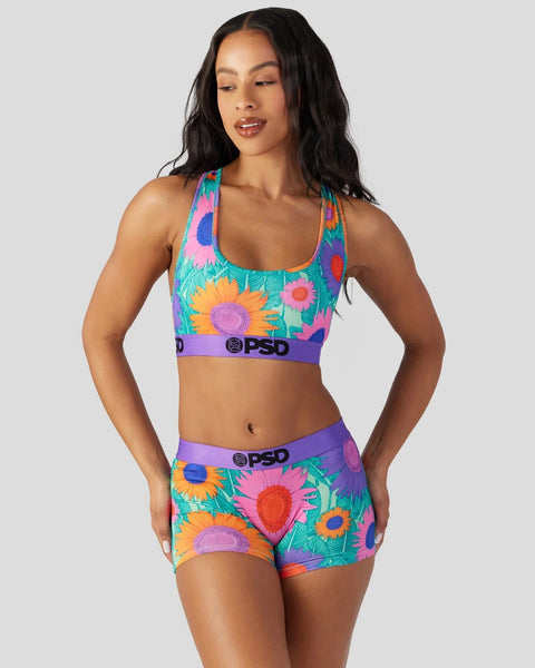 Colorful sports bra and shorts set with multicolored sunflower print on turquoise background and purple PSD waistbands.