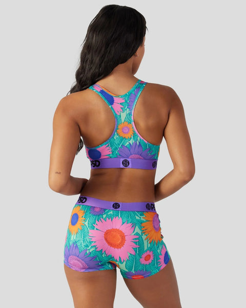 Colorful floral sports bra and shorts set with multicolored sunflowers and leaves on teal background, purple waistband detail