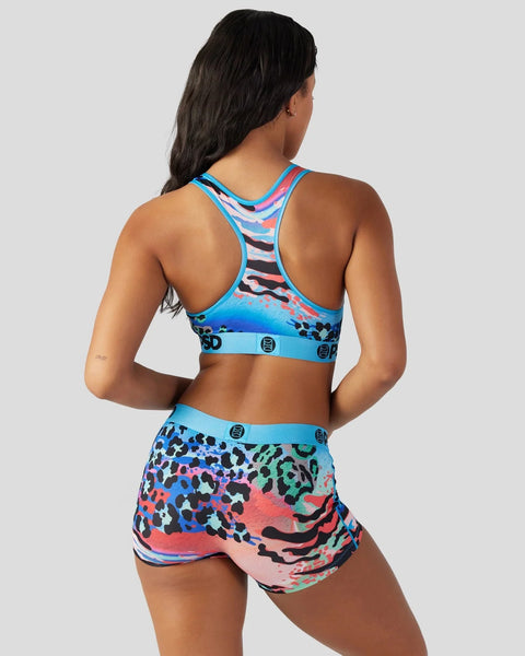 Woman wearing blue racerback sports bra and matching shorts with multicolored leopard and zebra print pattern.