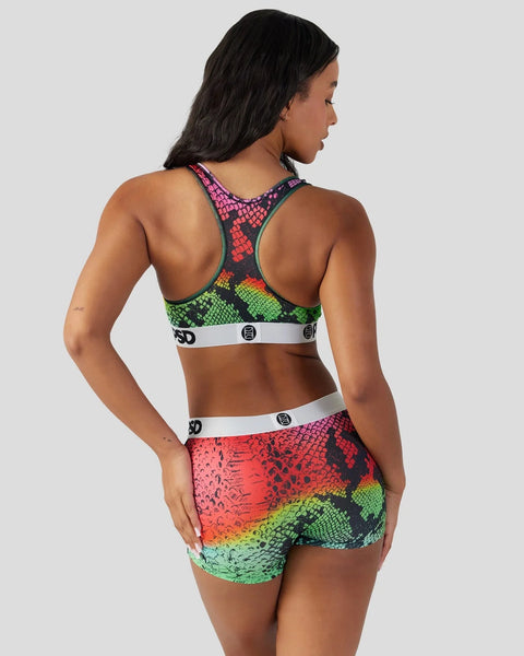 Women's sports bra and shorts set with multicolored snake scale print in red, green, and purple tones.