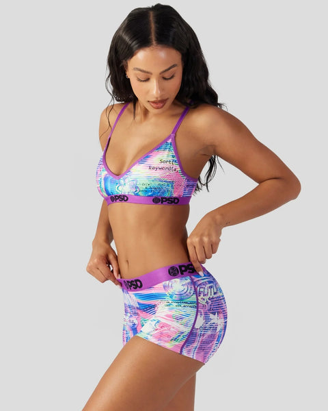 Woman wearing purple sports bra and matching shorts with holographic digital print pattern and branded waistbands.