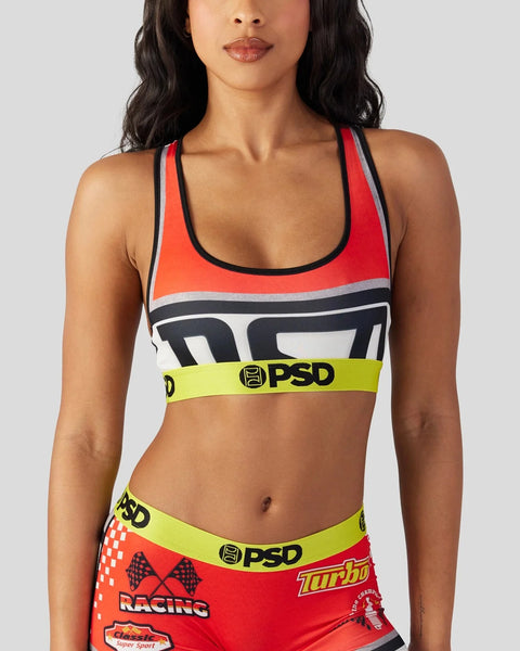 Woman wearing red, white, and black sports bra with PSD waistband and racing-themed graphics.