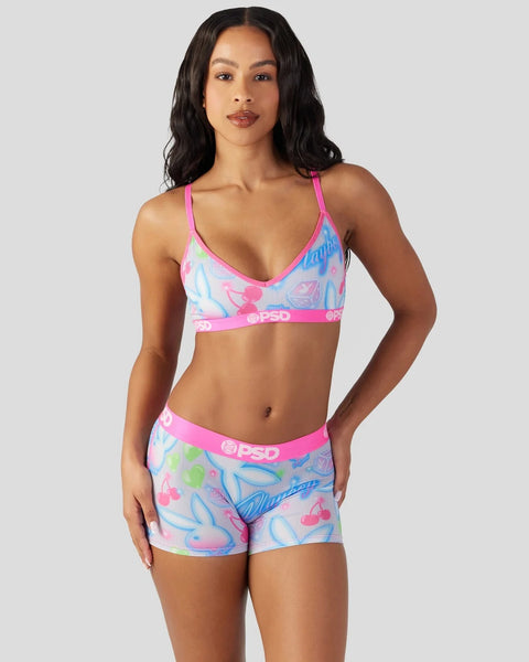 Woman wearing pink and blue patterned bikini top and shorts with PSD waistband.