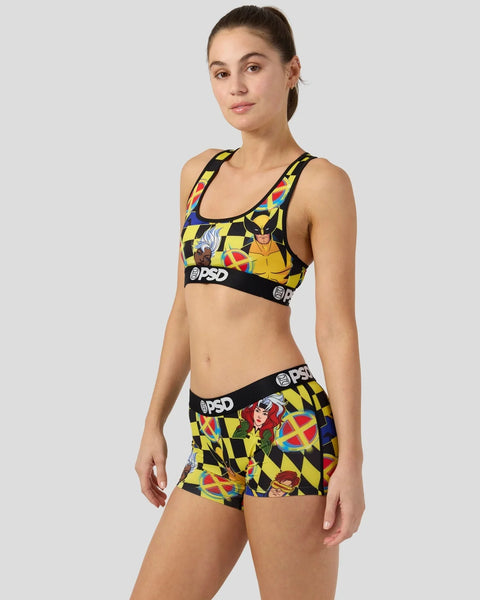 Woman wearing yellow and black checkerboard X-Men sports bra and shorts set with character graphics and PSD branding.