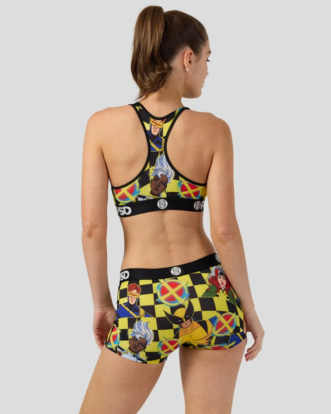 Woman wearing X-Men checkerboard print sports bra and shorts set with character graphics and black trim.