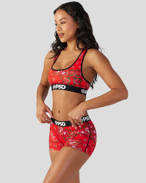 Red sports bra and shorts set with strawberry pattern and black elastic waistband.