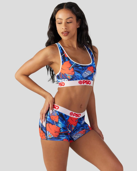 Woman wearing blue and orange patterned sports bra and matching shorts with white and red PSD branding.