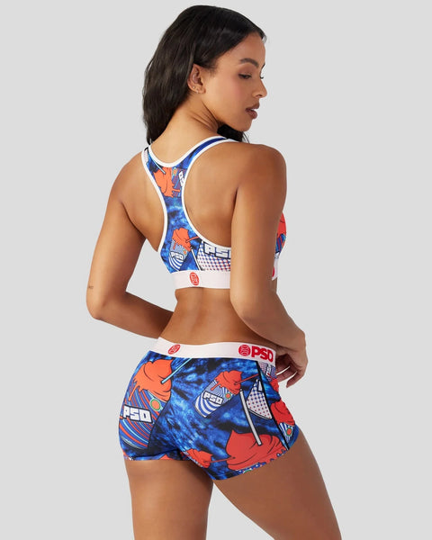 Woman wearing blue and orange graphic sports bra and matching shorts with white trim and red logo details.