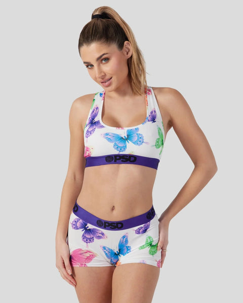 White sports bra and shorts set with multicolored butterfly print and purple waistband.