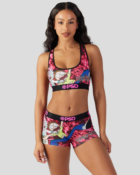 Woman wearing Rick and Morty graphic sports bra and shorts set with pink tie-dye and character print design.