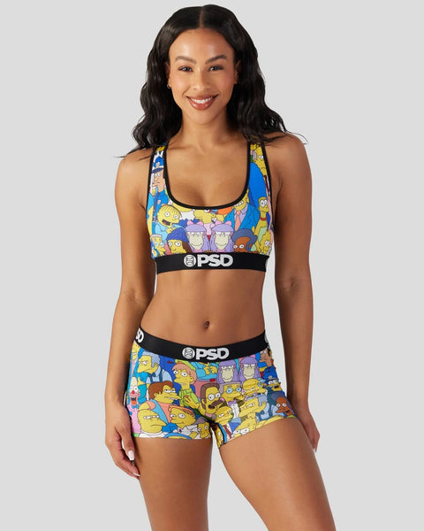 Woman wearing a Simpsons character-printed sports bra and shorts with black PSD waistband.