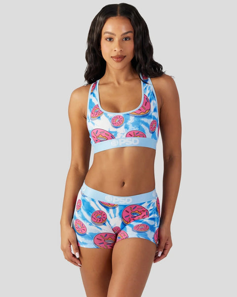 Woman wearing blue and pink tie-dye sports bra and shorts with donut print pattern.