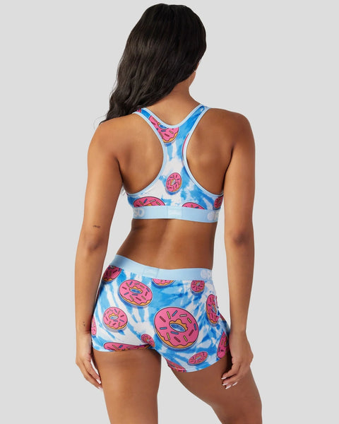 Blue and pink donut-patterned sports bra and shorts set on model, shown from back.