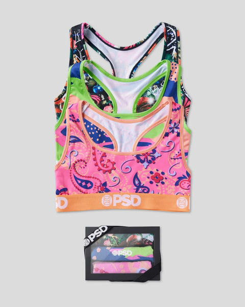 Three colorful sports bras with floral and geometric patterns in pink, green, navy, and multicolor designs displayed with pac
