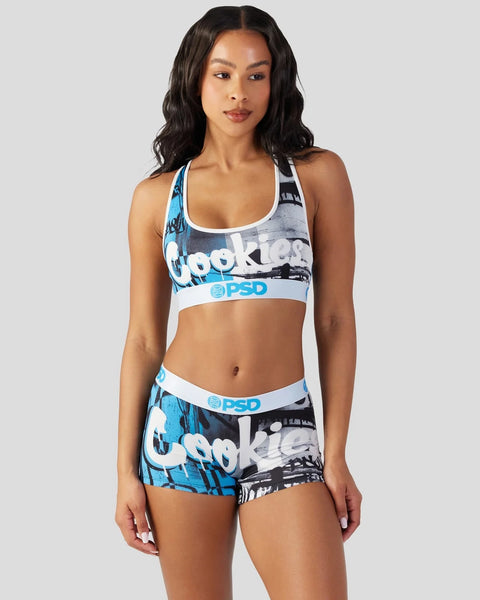 Woman wearing blue and black graphic sports bra and shorts set with white trim and PSD branding.