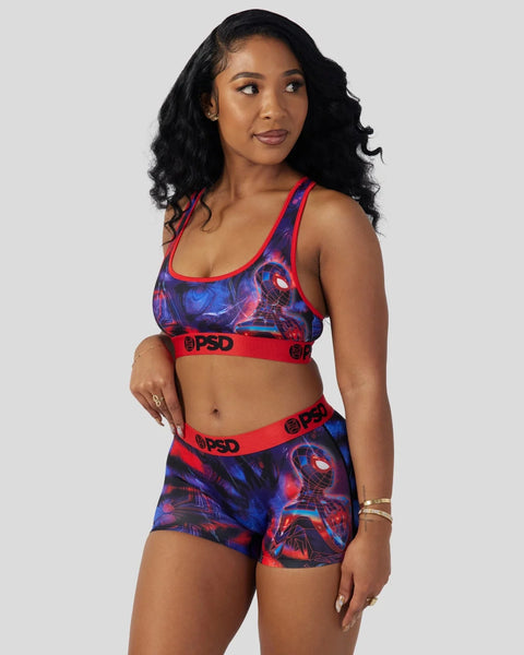 Woman wearing red and blue Miles Morales-themed sports bra and shorts with graphic print and red waistbands.