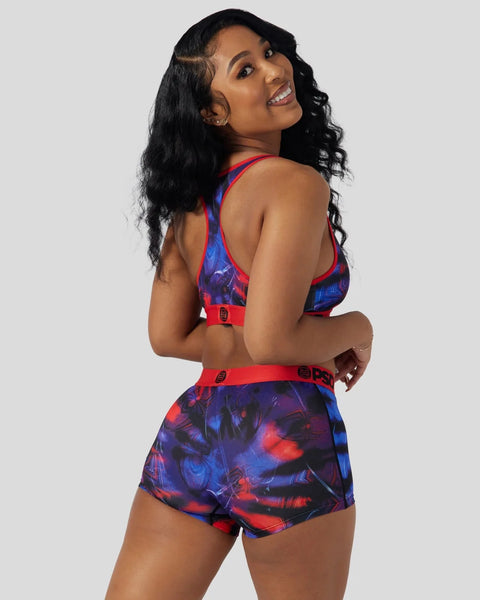 Woman wearing red and blue Miles Morales-themed sports bra and shorts with graphic print and red trim.