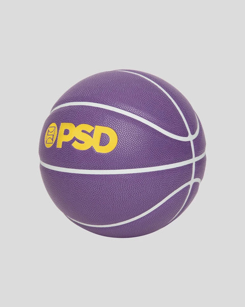 Purple basketball with white curved lines and yellow "PSD" branding on textured rubber surface.