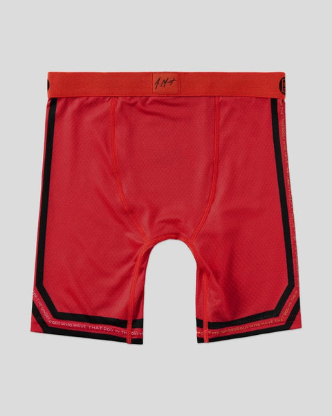 Red boxer briefs with black side panels and waistband trim featuring text detailing.