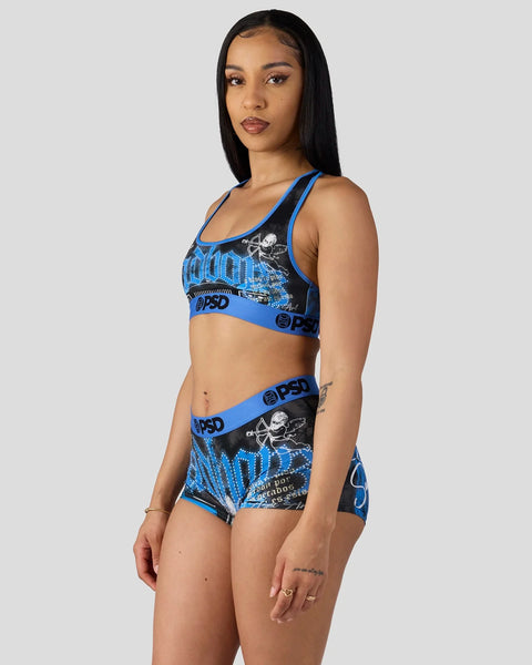 Woman wearing blue and black sports bra and shorts set with skull graphic and BPSD branding.