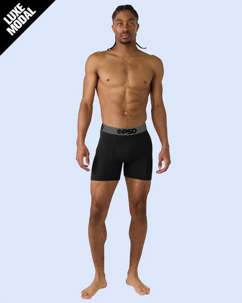 Man wearing black boxer shorts with grey waistband and PSD branding.