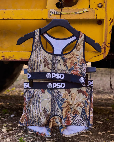 Sports bra and boxer shorts set with Realtree Xtra Grey camouflage print and PSD branding on black elastic bands.