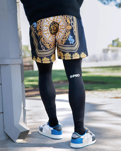 Black fitted leggings with PSD logo on thigh, worn under patterned shorts.