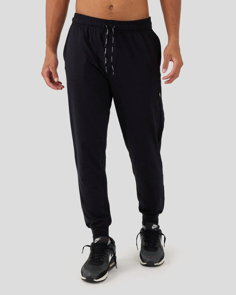 Black joggers with drawstring waistband and ribbed cuffs, worn with black athletic shoes.
