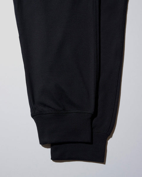 Black jogger pants with ribbed cuffs and seamed legs displayed flat against a white background.