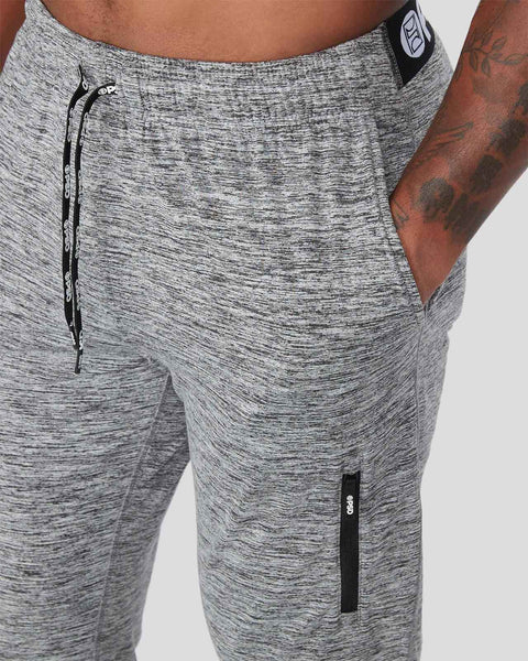 Grey heathered joggers with drawstring waist, side pockets, and black zip details on thighs.