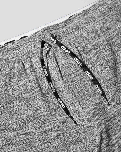 Grey heathered joggers with black drawstrings and branded eyelets, flat lay view.