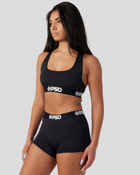 Black sports bra and shorts set with white PSD branding on elastic bands.