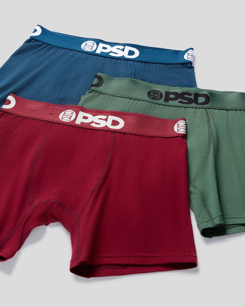 Three PSD boxer briefs in navy blue, sage green, and burgundy with branded waistbands stacked together.