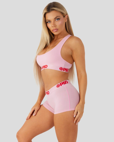 Pink sports bra and boy shorts with red logo waistband.