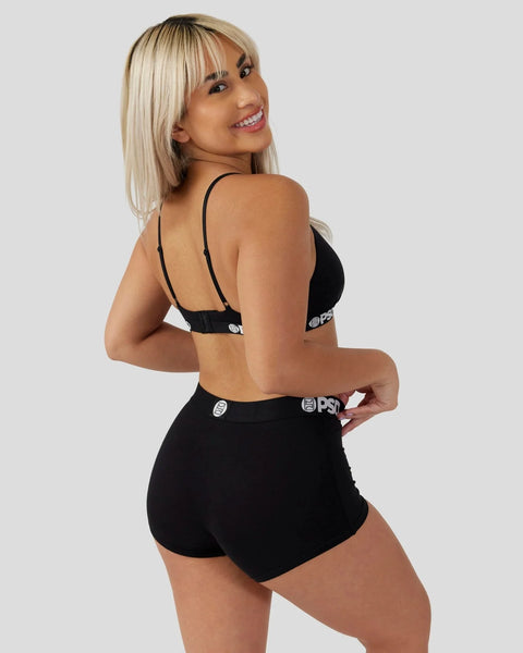 Black bralette and shorts set with branded waistband, shown on model from back.