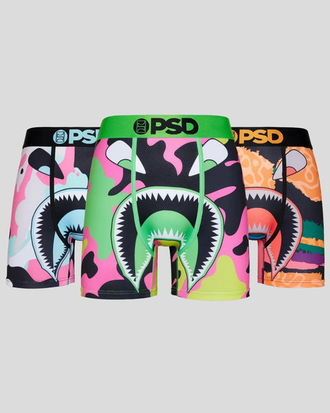 Three PSD boxer briefs with colorful camouflage patterns featuring monster face designs in black, pink, green, and orange.
