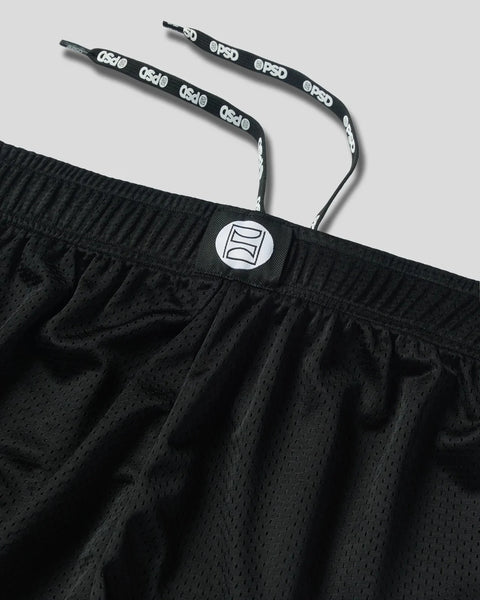 Black athletic short with perforated mesh fabric, elastic waistband, drawstring with branding, and white logo patch.